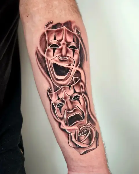 Theatrical comedy and tragedy masks with a rose in black and gray shading.