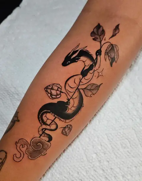 Stylized dragon entwined with leaves and abstract elements in blackwork style.