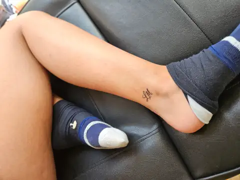 Fine line initials 'LM' tattoo placed delicately on the ankle.